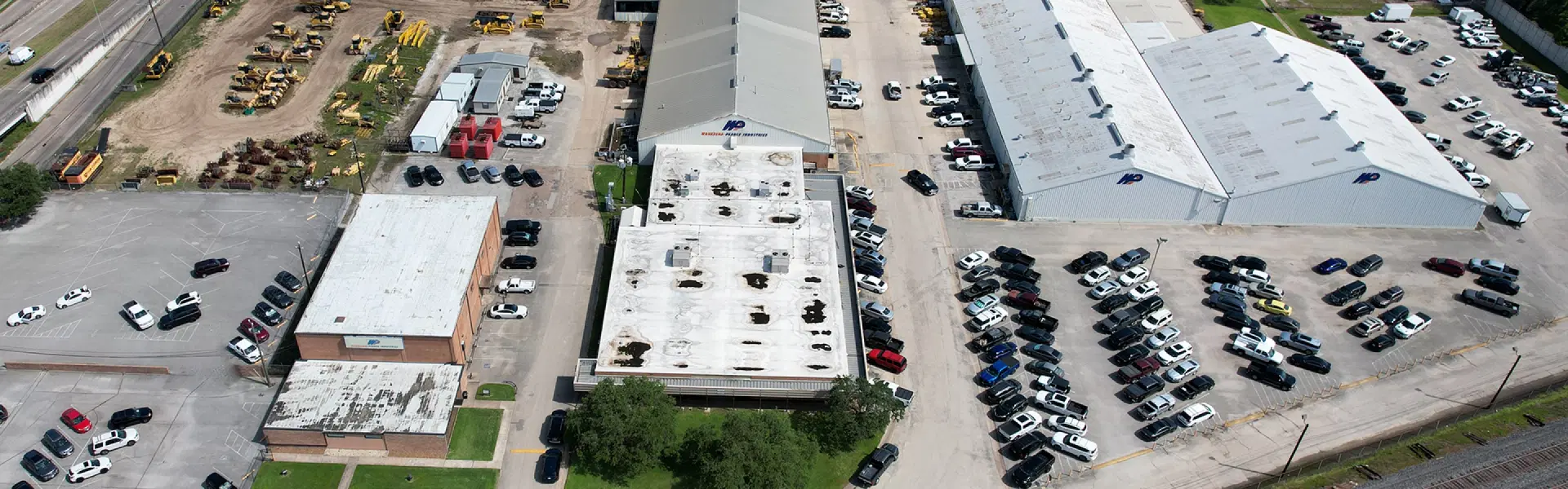 An aerial view of a large company and its parking lots.